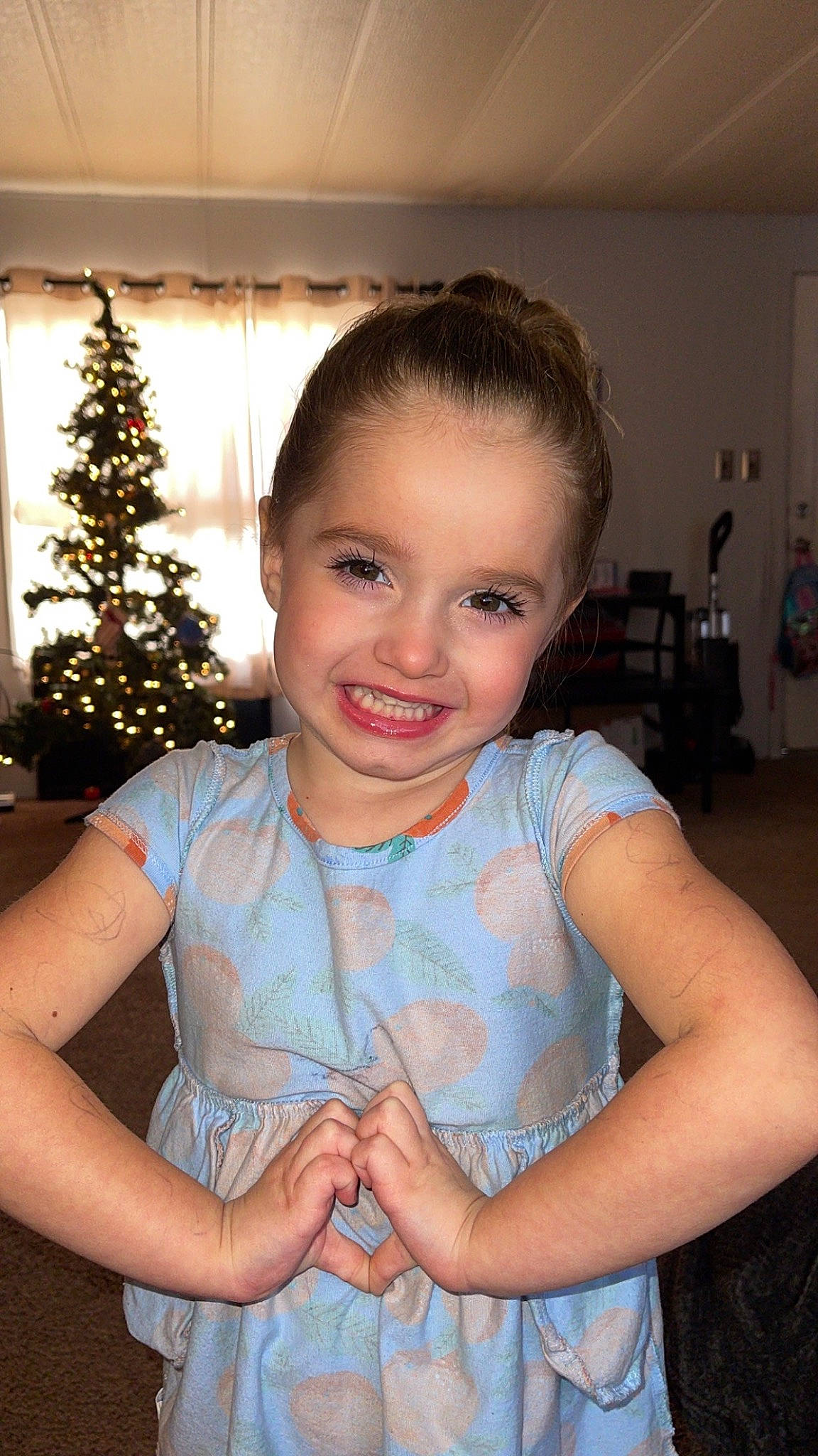 Madeline is registered to the contest to win money with this photo: child, chin, christmas_decoration, christmas_ornament, christmas_tree, conifer, dress, electric_blue, event, flash_photography, fun, happy, holiday, holiday_ornament, joy, ornament, pattern, person, sitting, smile