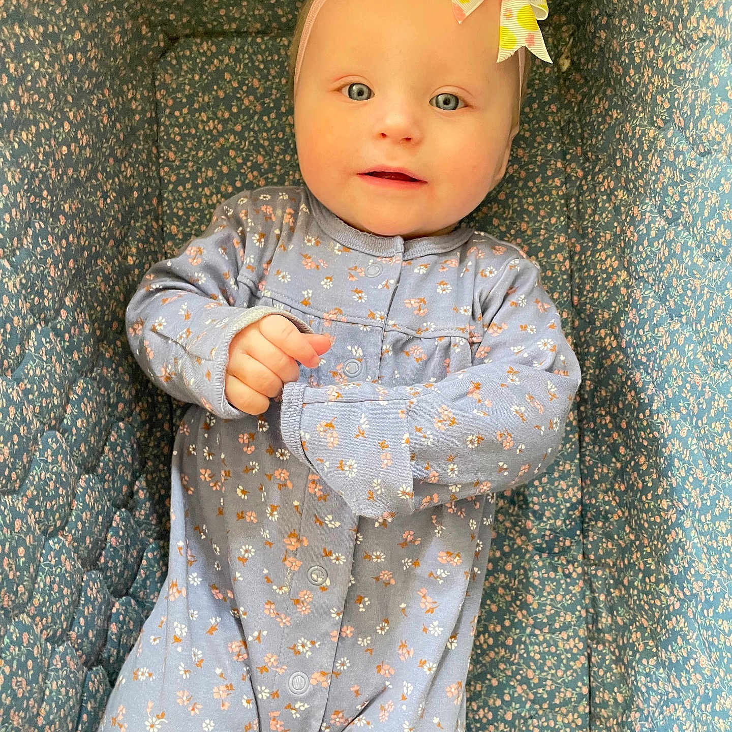 Nadiia Oakley-Reign joined the competition — help win amazing prizes! baby, blue, bow, child, crib, cushion, cute, eyes, face, floral_pattern, hand, headband, indoor, infant, lying_down, onesie, pastel_colors, portrait, sleepwear, smile