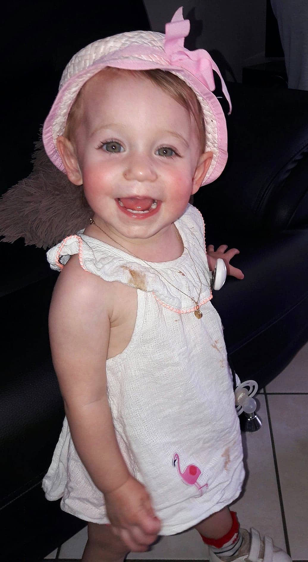 Clara participe au concours pour gagner de l'argent avec cette photo : baby, bonnet, cheek, child, child_model, dress, fashion_accessory, hair_accessory, hat, head, headgear, joy, lip, person, pink, skin, smile, sun_hat, toddler, vacation