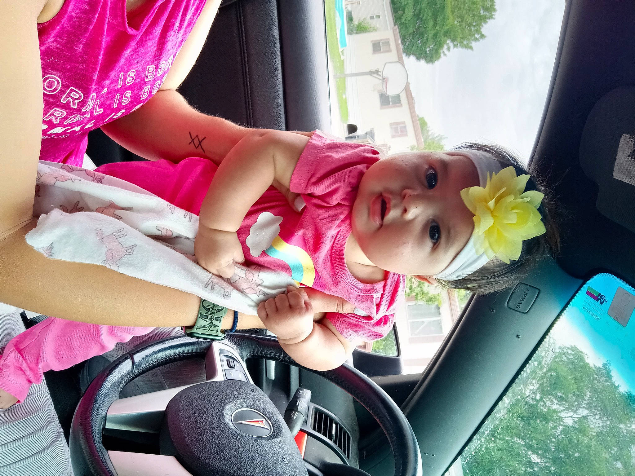 Dannika is registered to the contest to win money with this photo: auto_part, baby, car_seat, child, dress, finger, fun, happy, headwear, human_body, leisure, magenta, motor_vehicle, person, pink, plant, product, skin, thigh, toddler