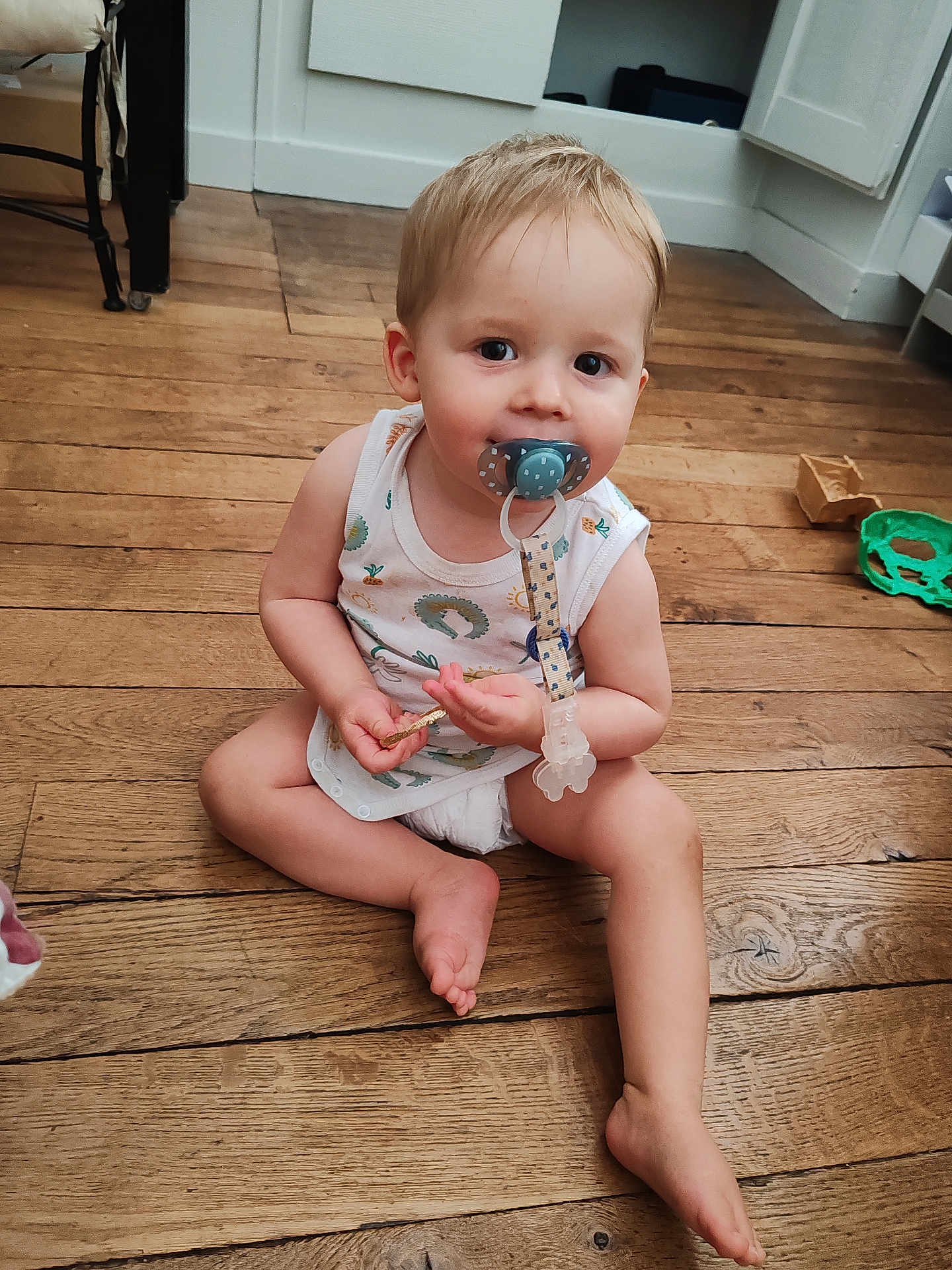 Eddy participe au concours pour gagner de l'argent avec cette photo : toddler, child, baby, pacifier, wooden_floor, sitting, indoor, toys, diaper, tank_top, curious, cute, young_child, flooring, home, person, furniture, clip, smile, barefoot