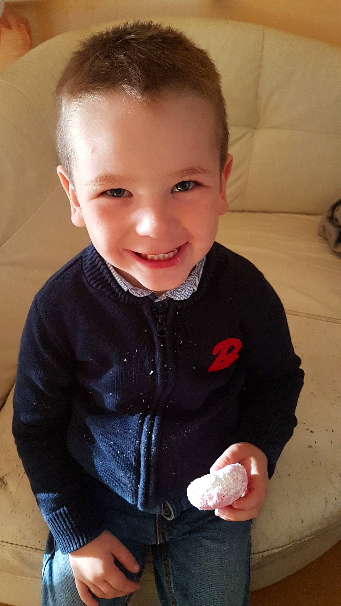 Hugo a rejoint le concours — aidez-le/la à gagner de superbes lots ! baby, baby_toddler_clothing, caesar_cut, cheek, child, couch, denim, ear, eye, finger, forehead, joy, laugh, living_room, organ, person, pleased, sitting, sleeve, thumb