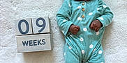 Aurora joined the competition — help win amazing prizes! baby, infant, polka_dot, onesie, headband, white_blanket, wooden_blocks, age_marker, lying_down, curious_expression, cute, newborn, soft_texture, hand, foot, buttoned_clothing, portrait, indoor, child, milestone