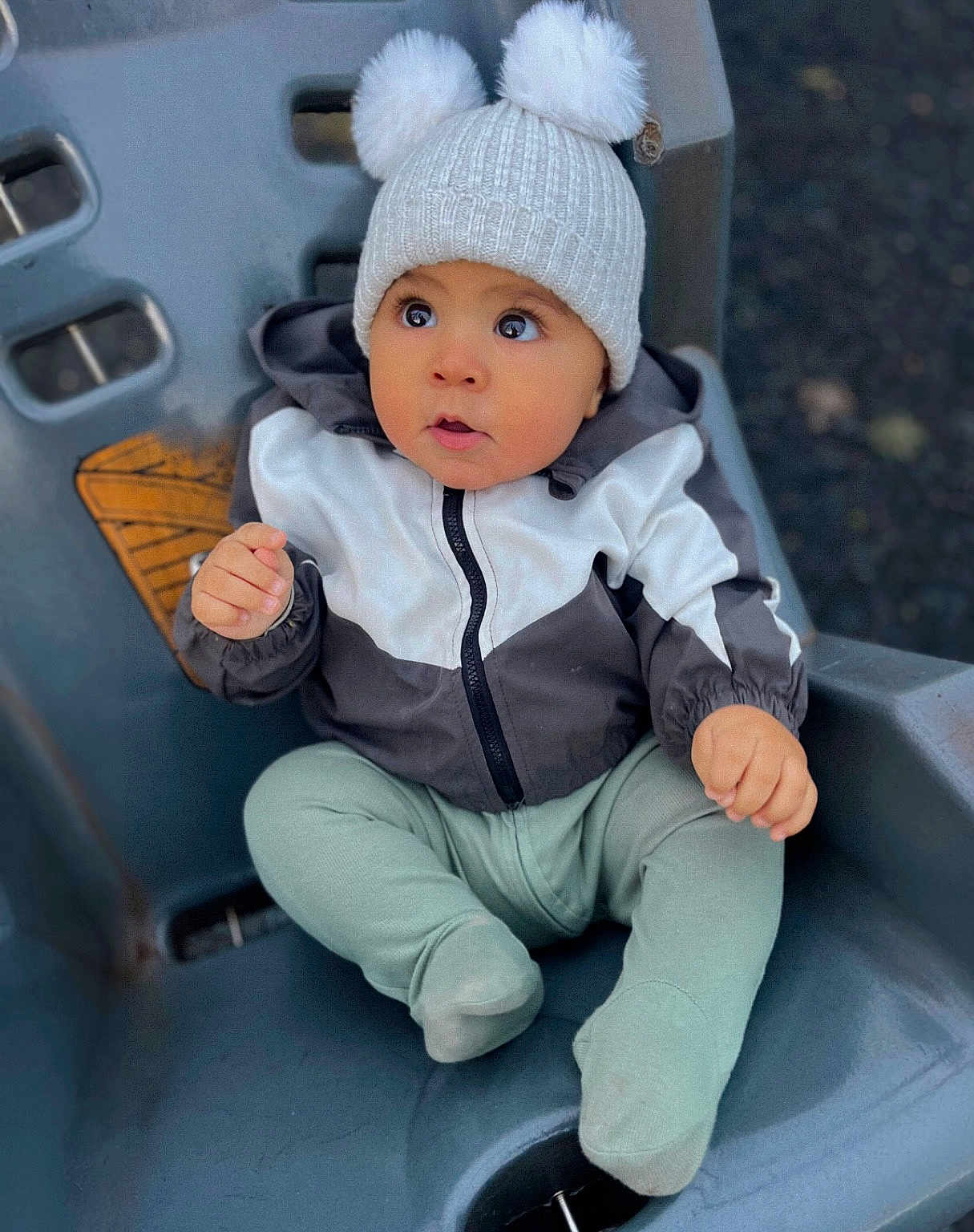 Raheem is registered to the contest to win money with this photo: baby, child, cozy, curious, cute, cute_baby, expression, eyes, face, hat, infant, jacket, outdoor, pom_poms, portrait, seat, sitting, small_hand, warm_clothes, winter_clothing