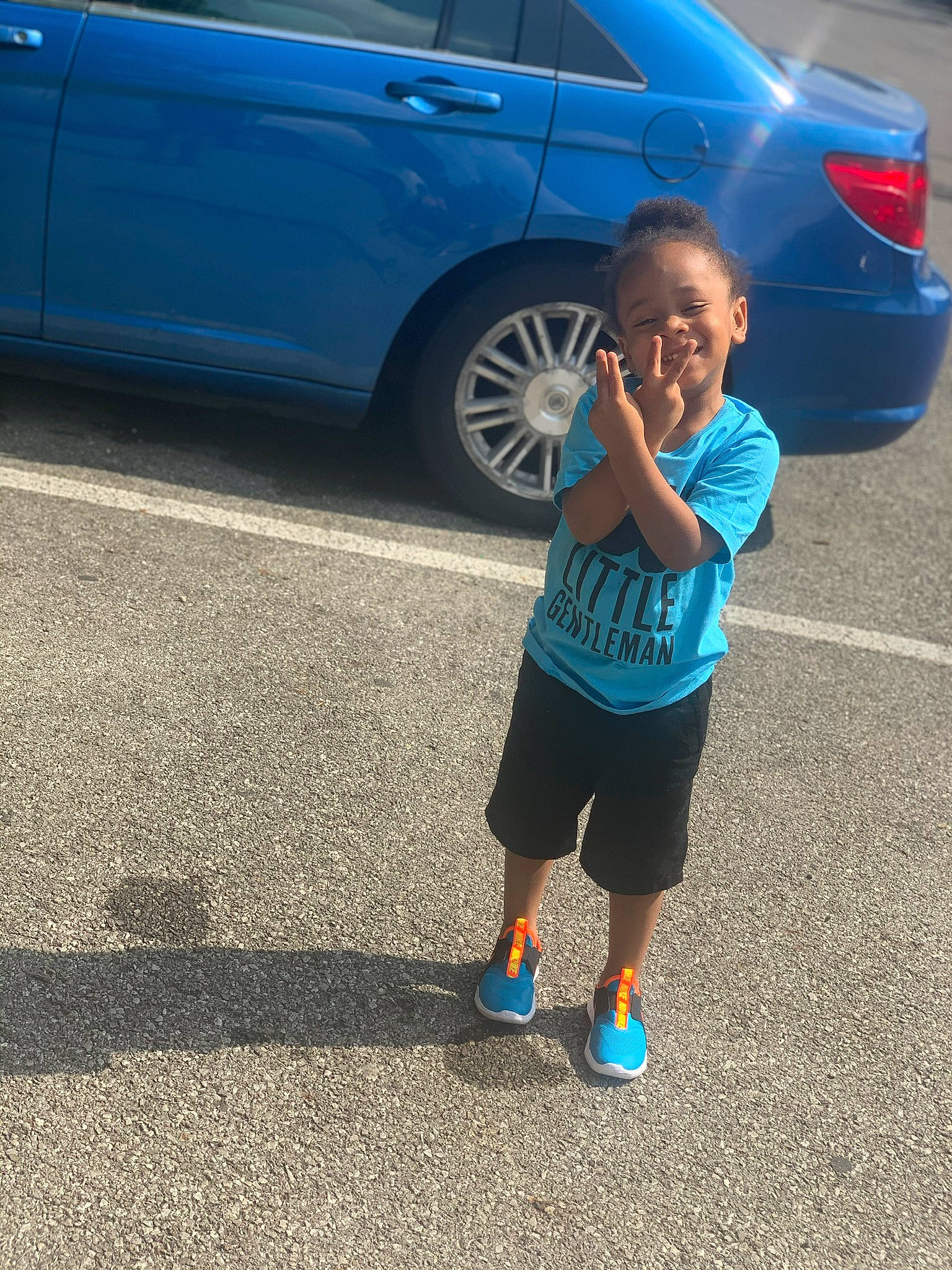 Tristen is registered to the contest to win money with this photo: automotive_exterior, automotive_lighting, blue, bmw, car, child, electric_blue, family_car, footwear, joy, luxury_vehicle, mid_size_car, person, personal_luxury_car, sky, sports_sedan, standing, toddler, vehicle, vehicle_door