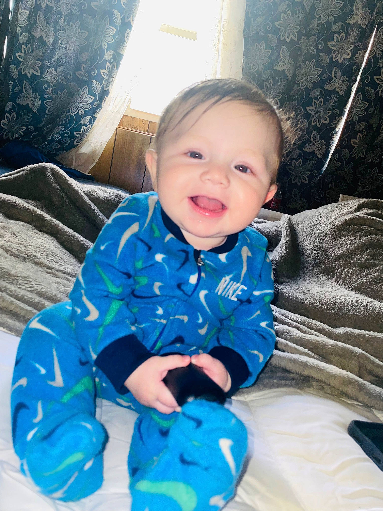 Amilio is registered to the contest to win money with this photo: azure, baby, baby_toddler_clothing, cheek, comfort, electric_blue, face, facial_expression, flash_photography, fun, happy, iris, mammal, person, purple, skin, sleeve, smile, standing, toddler
