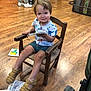 Léandre a rejoint le concours — aidez-le/la à gagner de superbes lots ! book, casual_clothing, chair, child, flooring, footwear, furniture, happy, indoor, leisure, person, playful, reading, sandals, shorts, smiling, toddler, tshirt, wooden_floor, young_child