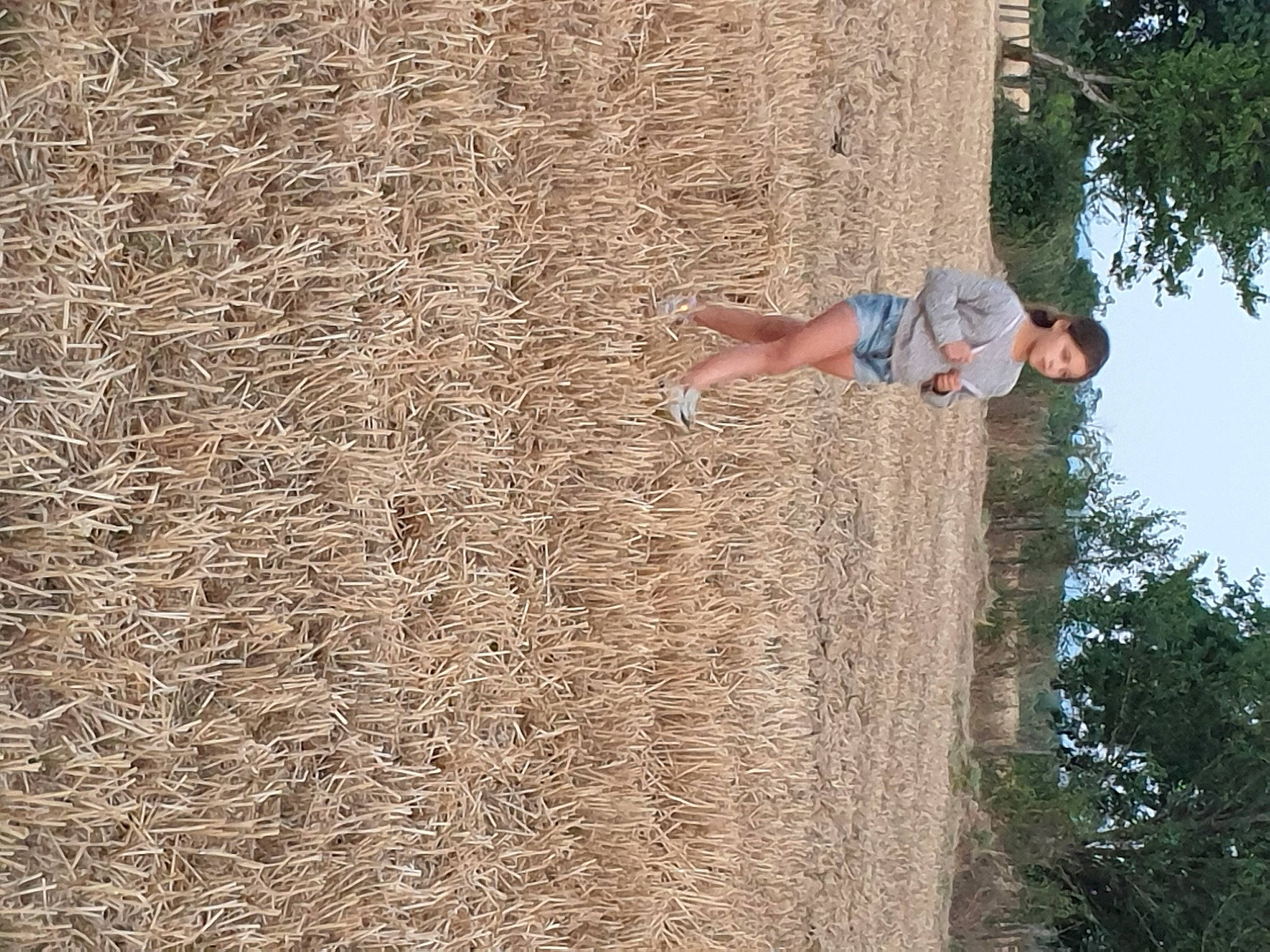 Léna participe au concours pour gagner de l'argent avec cette photo : agriculture, concrete, field, fun, grass, grass_family, happy, hay, leisure, people_in_nature, person, plant, recreation, shadow, sky, soil, straw, tree, trunk, wall