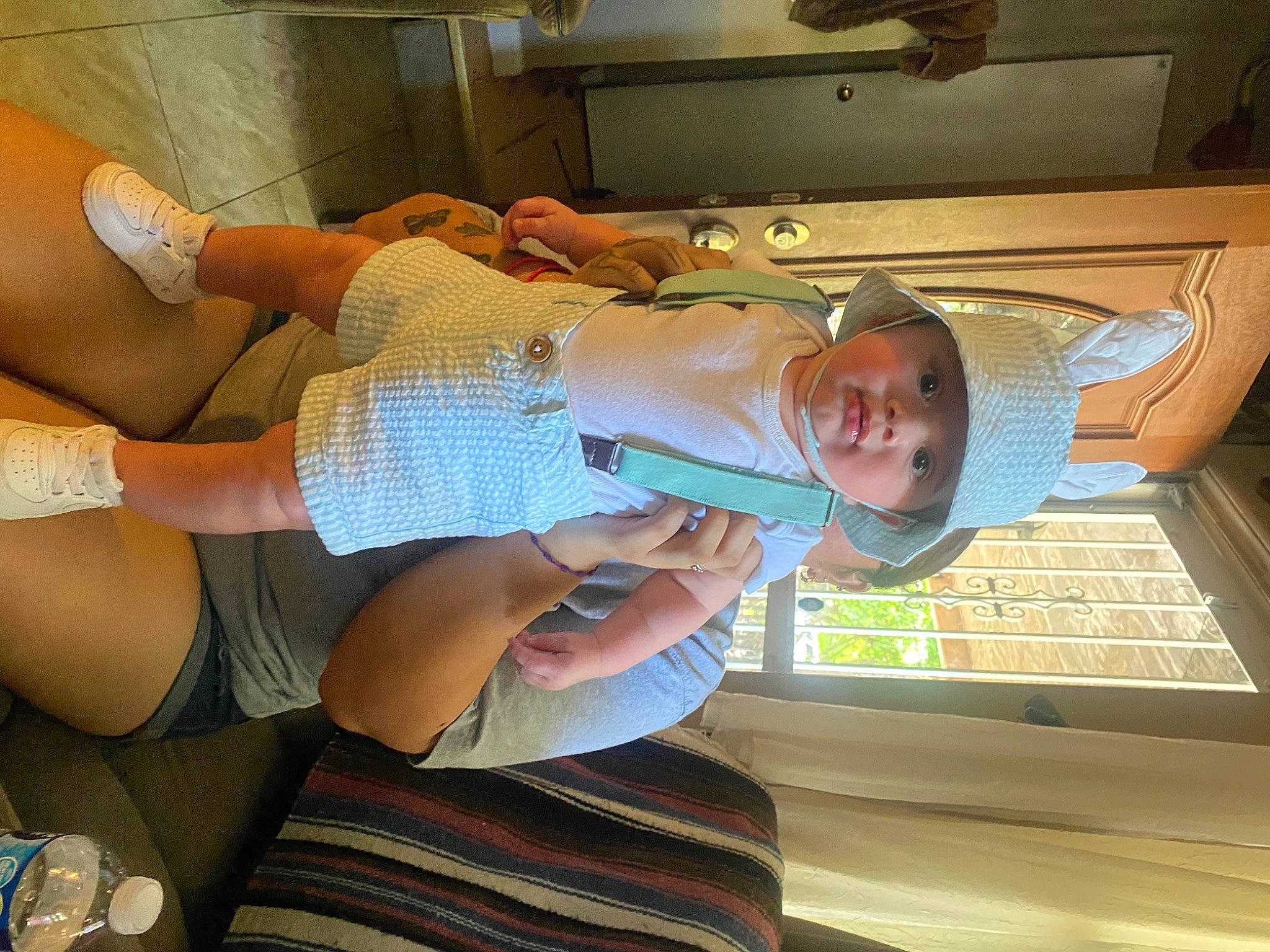Adan is registered to the contest to win money with this photo: abdomen, baby, baby_toddler_clothing, chest, child, comfort, elbow, foot, fun, hat, headwear, human_leg, knee, nail, person, room, smile, t_shirt, thigh, thumb
