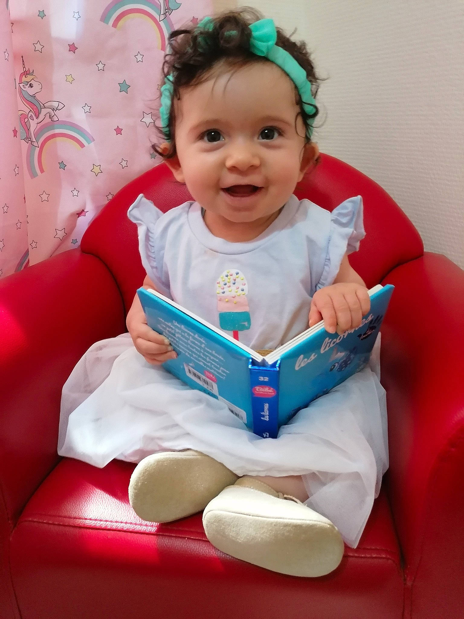 Nolwenn participe au concours pour gagner de l'argent avec cette photo : baby, baby_products, baby_toddler_clothing, child, comfort, dress, event, facial_expression, finger, fun, happy, headwear, human_body, joy, person, pink, product, red, sitting, sleeve