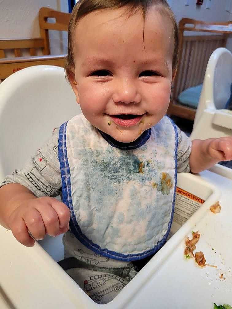 Zacheriah is registered to the contest to win money with this photo: baby, baby_toddler_clothing, chair, cheek, child, comfort_food, eating, face, facial_expression, finger, fun, happy, joy, nose, person, sitting, skin, sleeve, smile, t_shirt