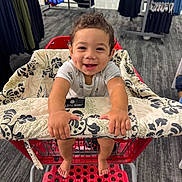 Makai joined the competition — help win amazing prizes! toddler, child, shopping_cart, smiling, curly_hair, indoor, clothing_store, carpet, handle_cover, barefoot, holding, person, retail, happy, cute, baby, shopping, rack, footrest, fabric