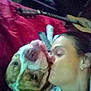 Woffie is registered to the contest to win money with this photo: person, dog, bulldog, kiss, bed, towel, red_bedspread, indoor, cozy, affection, blurred, guitar, furniture, pet, love, closeup, head, sleepwear, human, animal