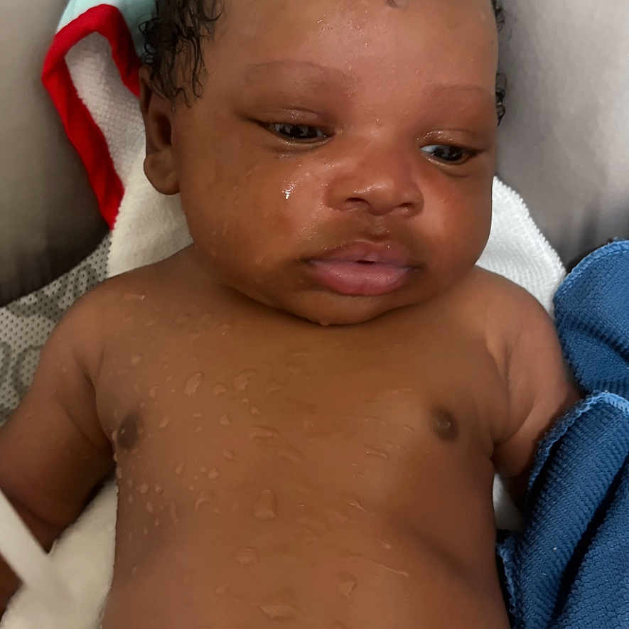 Dakari is registered to the contest to win money with this photo: baby, child, closeup, cute, expression, face, hooded_towel, indoors, infant, newborn, person, portrait, resting, skin, sleepy, soft, towel, water_droplets, wet_skin, young_child