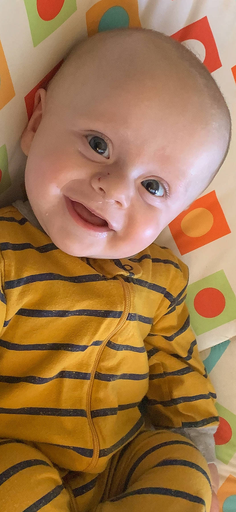 Kolton is registered to the contest to win money with this photo: arm, baby, baby_toddler_clothing, cheek, child, comfort, finger, fun, happy, iris, joy, mouth, nose, orange, pattern, person, pink, skin, sleeve, smile