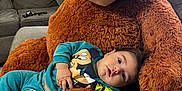 Thiago Garcias is registered to the contest to win money with this photo: baby, child, teddy_bear, plush, sofa, couch, furniture, indoor, cute, smiling, person, clothing, mickey_mouse, cartoon, relaxing, home, comfort, portrait, toy, soft