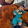 Thiago Garcias joined the competition — help win amazing prizes! baby, teddy_bear, plush_toy, couch, indoor, child, colorful_clothing, mickey_mouse, socks, hand, smartphone, window, curtains, relaxing, cute, infant, cozy, soft_toy, person, furniture