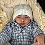Gurniwaz is registered to the contest to win money with this photo: baby, blanket, checkered, child, clothing, cozy, cute, expression, face, hand, hat, indoor, infant, jacket, knit_hat, newborn, person, portrait, soft_texture, warm