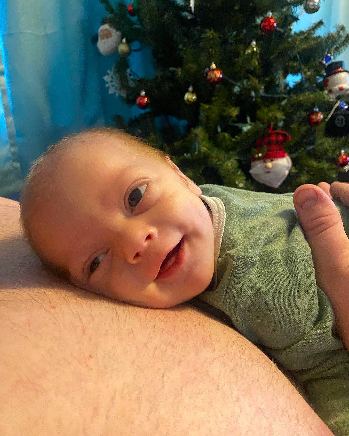 Jayce is registered to the contest to win money with this photo: baby, cheek, child, christmas_decoration, christmas_ornament, christmas_tree, event, evergreen, eye, grass, happy, holiday_ornament, human_body, iris, ornament, person, plant, skin, smile, toddler