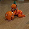 baby, child, costume, pumpkin, halloween, floor, wooden_floor, indoor, toy, fan, door, orange, green, crawling, plastic, headwear, holiday, festive, infant, person