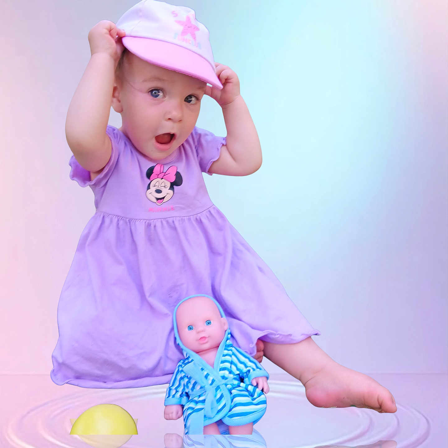 Ynnaïa a rejoint le concours — aidez-le/la à gagner de superbes lots ! blue, cap, child, cute, doll, dress, indoor, minnie_mouse, pastel_background, pink, playful, purple, reflection, robe, sitting, striped, surprised, toddler, toy, water_ripple