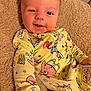 baby, infant, smiling, yellow_clothing, onesie, spongebob, blanket, soft_texture, happy, cute, face, portrait, child, indoor, cozy, hand, young_child, playful, comfort, casual