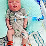 baby, infant, hospital, medical_equipment, oxygen_tube, onesie, shoes, pillow, bed, monitor, tubes, cute, child, patient, healthcare, newborn, person, lying_down, baby_clothes, medical_care