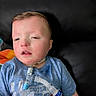 child, boy, medical_equipment, breathing_tube, tshirt, captain_america, blue_shirt, indoor, leather_sofa, person, face, healthcare, medical_care, resting, young_child, casual_clothing, closeup, sitting, patient, home