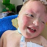 Bryant joined the competition — help win amazing prizes! child, smiling, medical_equipment, breathing_tube, closeup, indoor, blue_blanket, plush_toy, dinosaur_toy, face, skin, happy, person, healthcare, cute, infant, baby, toddler, expression, portrait