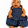 baby, infant, child, denim_dress, headband, bow, smiling, happy, cute, lying_down, white_background, baby_clothes, newborn, sock, portrait, skin, hands, face, eyes, adorable