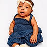 Merci joined the competition — help win amazing prizes! baby, child, denim_dress, headband, bow, socks, sitting, portrait, cute, infant, studio, white_background, hands, smiling, fashion, apparel, footwear, person, young, expression