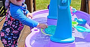 Isabella joined the competition — help win amazing prizes! child, daytime, deck, floral_clothing, grass, happy, house, outdoor, pink_shoes, playing, smiling, summer, sun_hat, sunny, toddler, toy, tree, water_play, water_table, wooden_deck