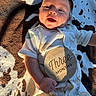 baby, infant, child, smiling, portrait, lying_down, blanket, cow_pattern, milestone, three_months, plaque, onesie, clothing, sunlight, indoor, close_up, face, happy, photography, family_moment
