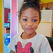 Darius is registered to the contest to win money with this photo: child, curly_hair, tshirt, minnie_mouse, indoor, kitchen, refrigerator, yellow_wall, playful_expression, earrings, doorway, furniture, person, portrait, smile, cute, young_child, home, living_space, casual_clothing