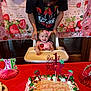 baby, birthday, cake, celebration, child, decorations, high_chair, party, person, pink, smile, strawberry, table, toddler, young_child, happy, food, icing, adult, background