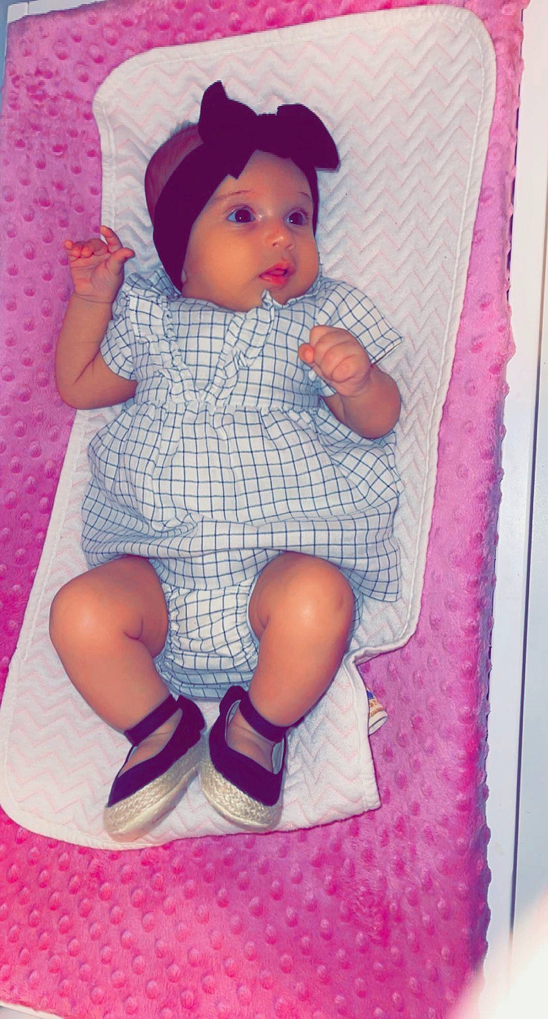 Julia is registered to the contest to win money with this photo: baby, baby_toddler_clothing, cap, cheek, child, doll, headwear, human_leg, lap, linens, magenta, pattern, person, pink, product, purple, sleeve, sock, textile, thigh