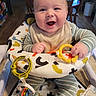 Wylde is registered to the contest to win money with this photo: baby, baby_walker, bib, chair, child, cute, face, green_toy, happy, indoor, infant, kitchen, person, sitting, smiling, striped_clothing, table, toy, wood_floor, yellow_toy