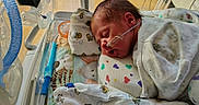 Nash joined the competition — help win amazing prizes! baby, bed, blanket, child, closeup, colorful, cute, face, healthcare, hospital, incubator, infant, medical_equipment, newborn, pediatric, person, resting, sleeping, soft, tube