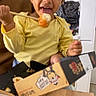 Emmanuel participe au concours pour gagner de l'argent avec cette photo : child, yellow_shirt, sushi, chopsticks, food, table, indoor, smiling, happy, person, brown_hair, face, tongue_out, box, meal, seated, casual, dining, home, playful