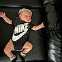 Amar joined the competition — help win amazing prizes! baby, sleeping, nike, onesie, black, socks, couch, leather, infant, child, clothing, footwear, headwear, relaxing, indoor, cute, portrait, resting, small, person
