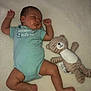 baby, sleeping, onesie, blue_clothing, teddy_bear, plush_toy, blanket, infant, soft_texture, cute, peaceful, lying_down, child, indoors, comfort, nap, adorable, resting, small_child, stuffed_animal