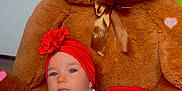Lucie a rejoint le concours — aidez-le/la à gagner de superbes lots ! baby, teddy_bear, plush_toy, red_headwrap, red_skirt, white_sweater, cute, indoors, carpet, child, heart_effects, soft_toy, portrait, infant, smiling, crawling, decor, warm_colors, playful, adorable