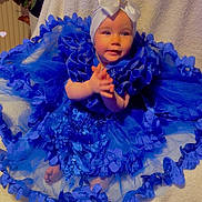 Lucie a rejoint le concours — aidez-le/la à gagner de superbes lots ! baby, blue_dress, headwrap, bow, frills, sitting, blanket, hearts, cute, indoors, plant, decor, portrait, child, smiling, soft_lighting, fabric, tulle, adorable, happy