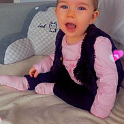 Lucie participe au concours pour gagner de l'argent avec cette photo : toddler, child, pink_bow, smiling, sitting, blanket, heart_effects, indoor, cute, happy, baby, soft_toys, furniture, clothing, vest, socks, face, person, portrait, home