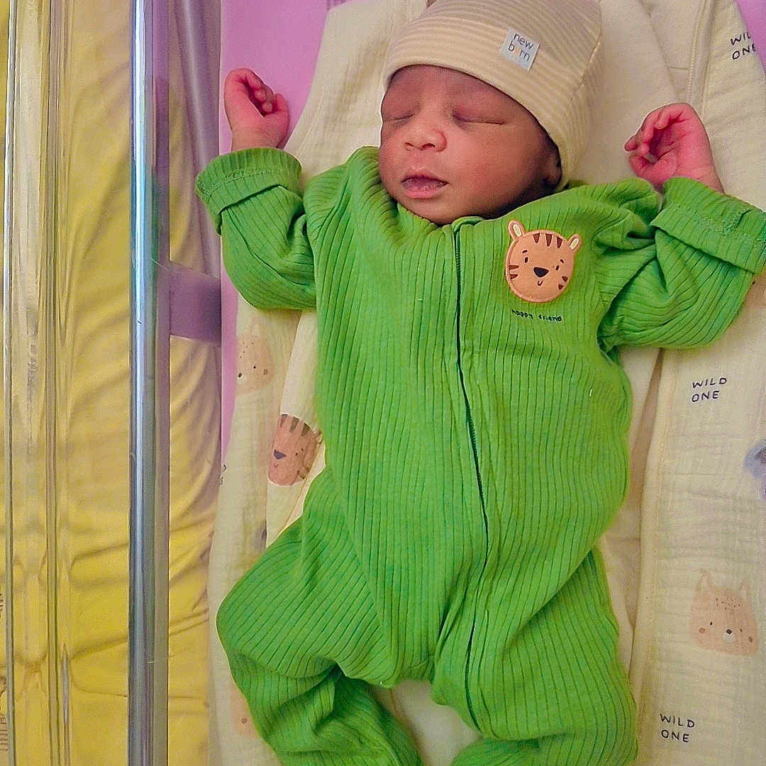 Fanildine participe au concours pour gagner de l'argent avec cette photo : animal_print, baby, baby_clothes, bed, blanket, child, cute, green_clothing, hat, hospital_bassinet, indoor, infant, newborn, onesie, peaceful, person, portrait, resting, sleeping, soft_toys