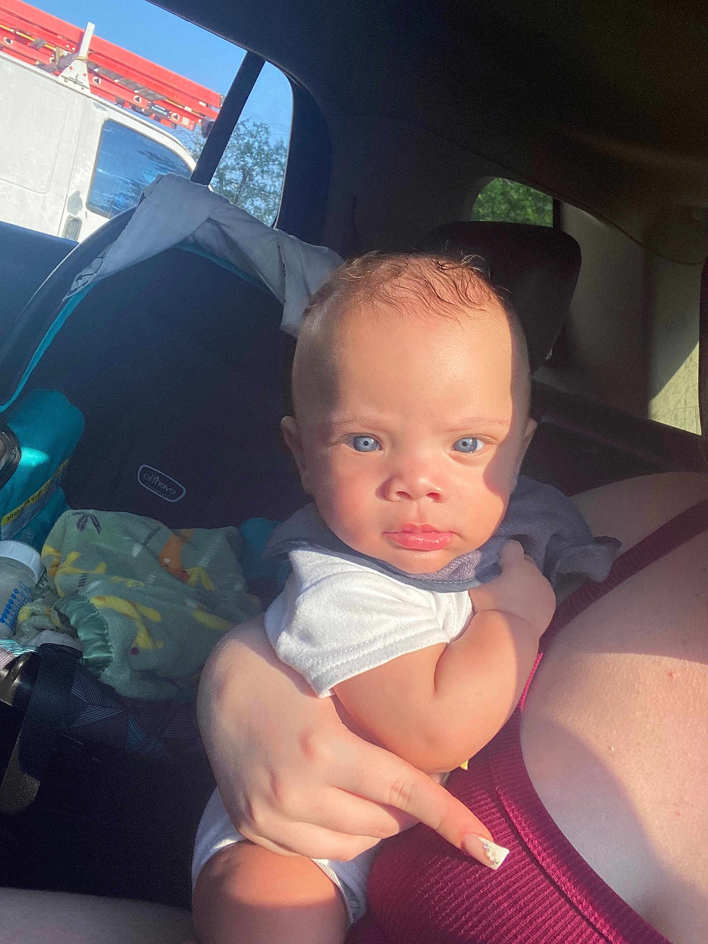 Ramontez joined the competition — help win amazing prizes! baby, child, blue_eyes, car_interior, car_seat, sunlight, person, arm, clothing, blanket, bottle, window, seatbelt, skin, face, hand, infant, holding, transportation, vehicle