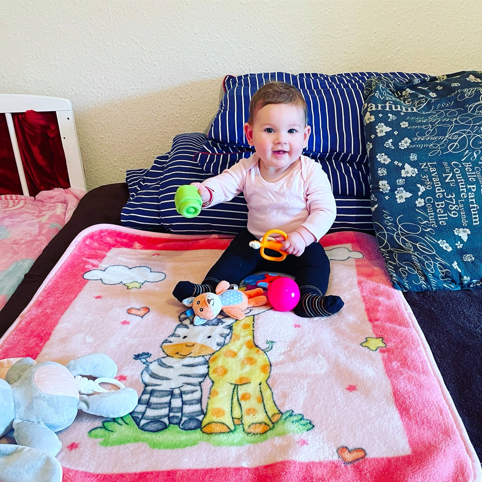 Karina is registered to the contest to win money with this photo: art, baby, baby_toddler_clothing, child, comfort, couch, floor, flooring, head, linens, magenta, mammal, pattern, person, pink, product, sleeve, textile, toddler, toy