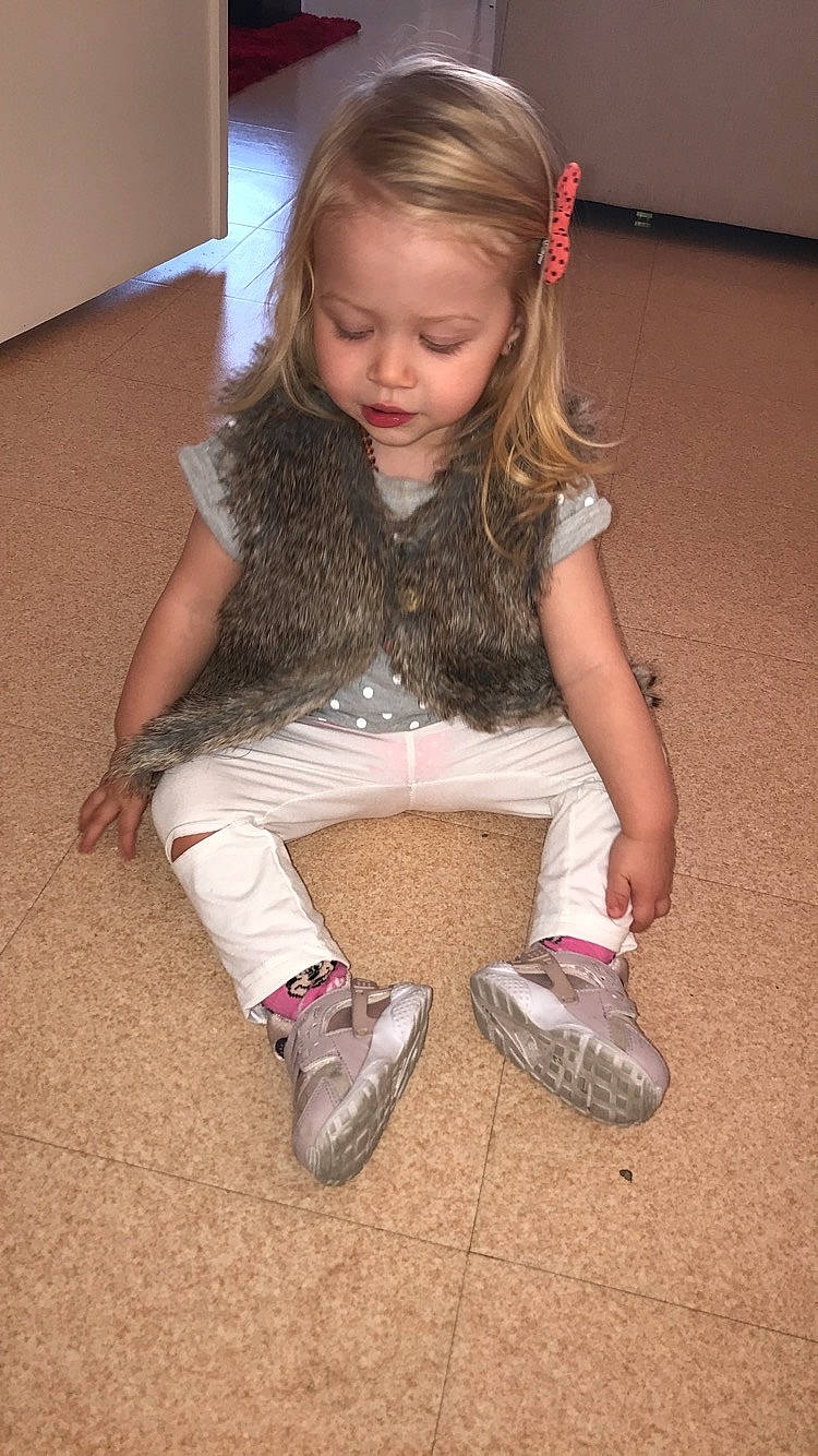 Cecilia participe au concours pour gagner de l'argent avec cette photo : abdomen, arm, blond, child, finger, flooring, footwear, fun, girl, hand, human_body, human_hair_color, leg, person, shoe, sitting, skin, smile, textile, toddler