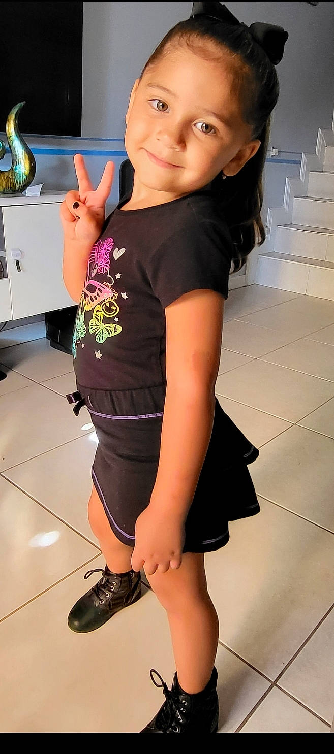 Darleen is registered to the contest to win money with this photo: black_hair, elbow, finger, flooring, gesture, hair, happy, human_leg, joint, joy, knee, leg, long_hair, neck, person, shoulder, sleeve, smile, t_shirt, thigh