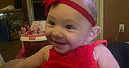 Brinlee joined the competition — help win amazing prizes! baby, child, red_dress, headband, smile, indoor, play_area, toy, furniture, door, person, face, happy, cute, infant, home, arm, skin, clothing, portrait